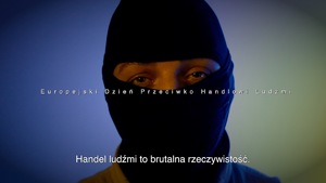 Stopklatka z filmu.Głowa mężczyzny w kominiarce. Na środku napis.Europejski Dzień Przeciwko Handlowi Ludźmi.