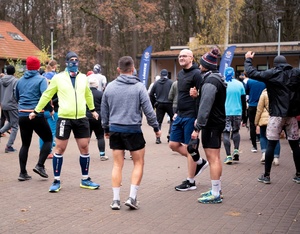 Pięcioosobowa drużyna tomaszowskich policjantów w strojach sportowych na Niebieskim Biegu Niepodległości 2024 w lesie łagiewnickim na terenie Łodzi.