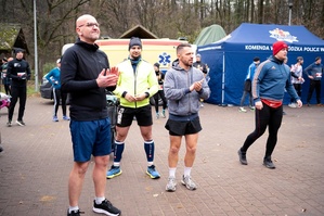 Pięcioosobowa drużyna tomaszowskich policjantów w strojach sportowych na Niebieskim Biegu Niepodległości 2024 w lesie łagiewnickim na terenie Łodzi.