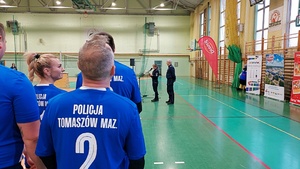 Rozpoczęcie turnieju siatkowego na terenie hali sportowej drużyny stoją w grupach podczas okolicznościowych przemówień.