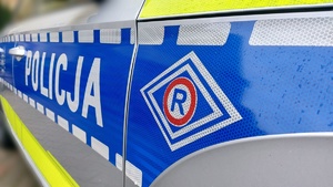 Policyjny radiowóz z napisem Policja i logo ruchu drogowego, litera R wpisana w romb.