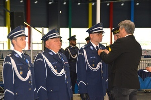 Prezes Stowarzyszenia Rodzina Policyjna 1939 roku w Łodzi, przypina medale do munduru wyróżnionych policjantów i przedstawiciela innych służb mundurowych.