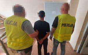 Policjanci w trakcie doprowadzenia mężczyzny do pomieszczeń dla osób zatrzymanych.