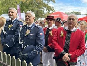 Komendant Powiatowy Policji w Tomaszowie Maz. inspektor Tomasz Jędrzejczyk na zdjęciu wraz  podinspektorem Dariuszem Grałkiem zastępcą Komendanta Komisariatu Policji w Czerniewicach i uczestnikami dożynek.