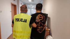 Funkcjonariusz policji z zatrzymanym trzydziestolatkiem.