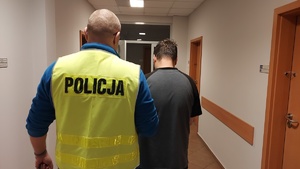 Funkcjonariusz policji z zatrzymanym dwudziestodziewięciolatkiem.