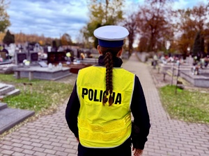 Funkcjonariuszka Policji w trakcie patrolowania terenu cmentarza.