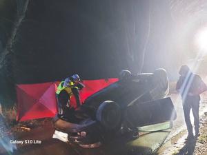 Funkcjonariusze policji w trakcie oględzin pojazdu uczestniczącego w wypadku.