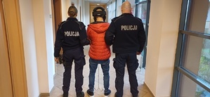 Umundurowani funkcjonariusze Policji w trakcie doprowadzenia zatrzymanego 41-latka.