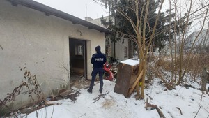 Umundurowana funkcjonariuszka policji w trakcie kontroli pustostanu.