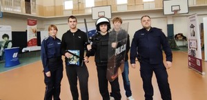 Policjanci z uczniami odwiedzajacymi targi.