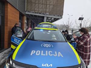 Dzieci oglądające policyjny radiowóz.