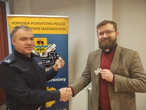 Naczelnik Wydziału Ruchu Drogowego KPP w Tomaszowie Maz. podispektor Andrzej Mela oraz ksiądz Bogusław Sebesta w trakcie przekazania odblaskowych aniołów.