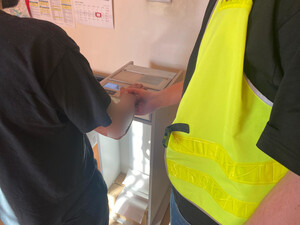 Zatrzymany mężczyzna podczas daktyloskopii.