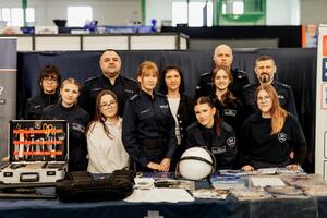 Umundurowani funkcjonariusze, pracownice Zespołu Kadr i uczniowie klasy mundurowej na stoisku policyjnym podczas VII Targów Pracy i Edukacji.