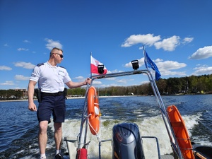 Funkcjonariusz Policji patrolujący z łodzi teren Zalewu Sulejowskiego.